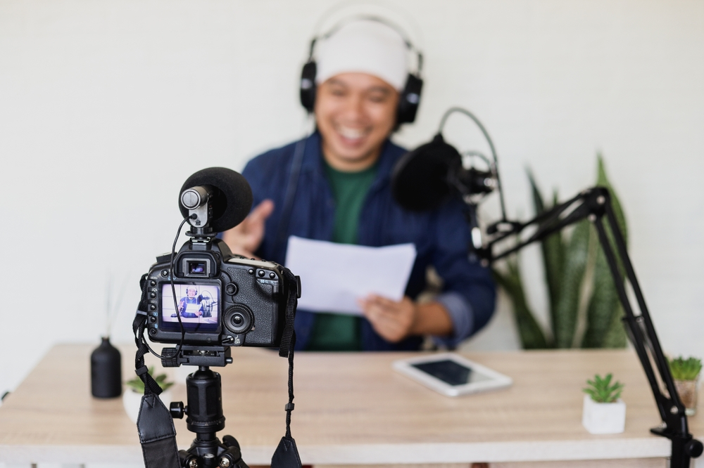 Criador de conteúdo gravando um vídeo para seu canal, mostrando como vídeos e podcasts são ferramentas eficazes dentro do Marketing Digital para engajar audiências.