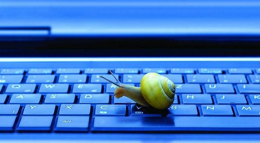 Um caracol amarelo se movendo lentamente sobre o teclado de um laptop, simbolizando um desempenho lento. No contexto de Marketing de Conteúdo, isso pode representar a importância de otimizar a velocidade de carregamento e a performance do site para engajar o público sem frustrações.