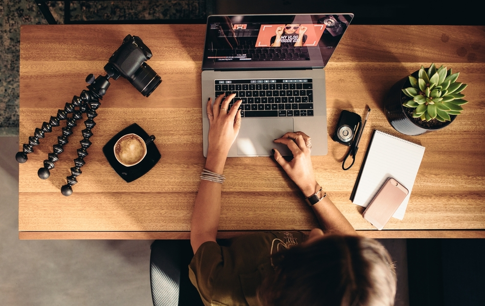 Criador de conteúdo digital produzindo material para redes sociais em ambiente criativo e organizado.