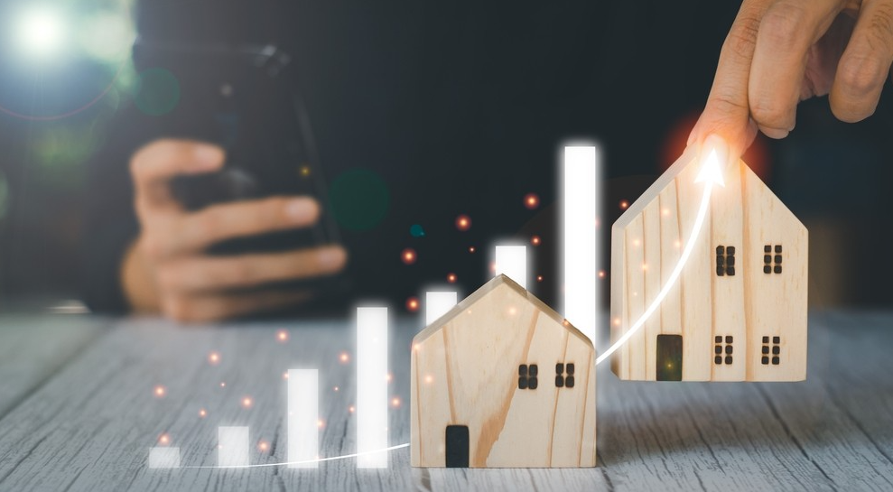 Casas em miniatura com gráfico ascendente, representando investimento imobiliário e análise de mercado como meios para entender como ganhar dinheiro com ativos físicos.