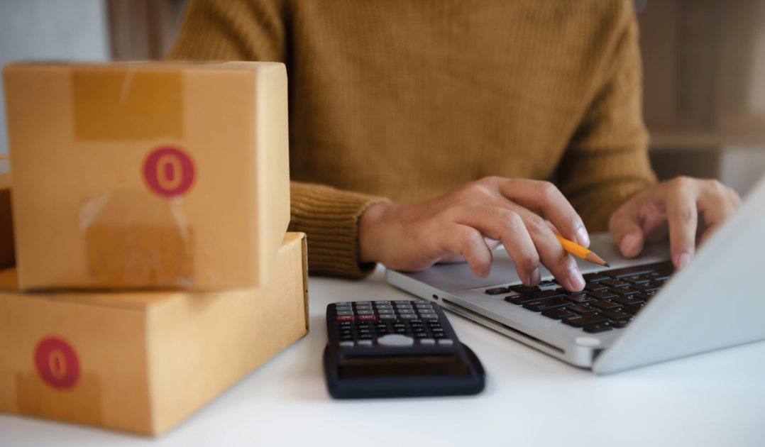 Empreendedor preparando pedidos ao lado de caixas de produtos, retratando uma das estratégias práticas de como ganhar dinheiro com e-commerce.