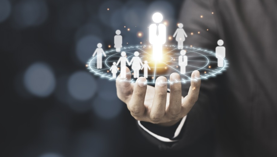 Mão segurando ícones holográficos de pessoas conectadas, destacando a construção de relacionamentos através do networking.