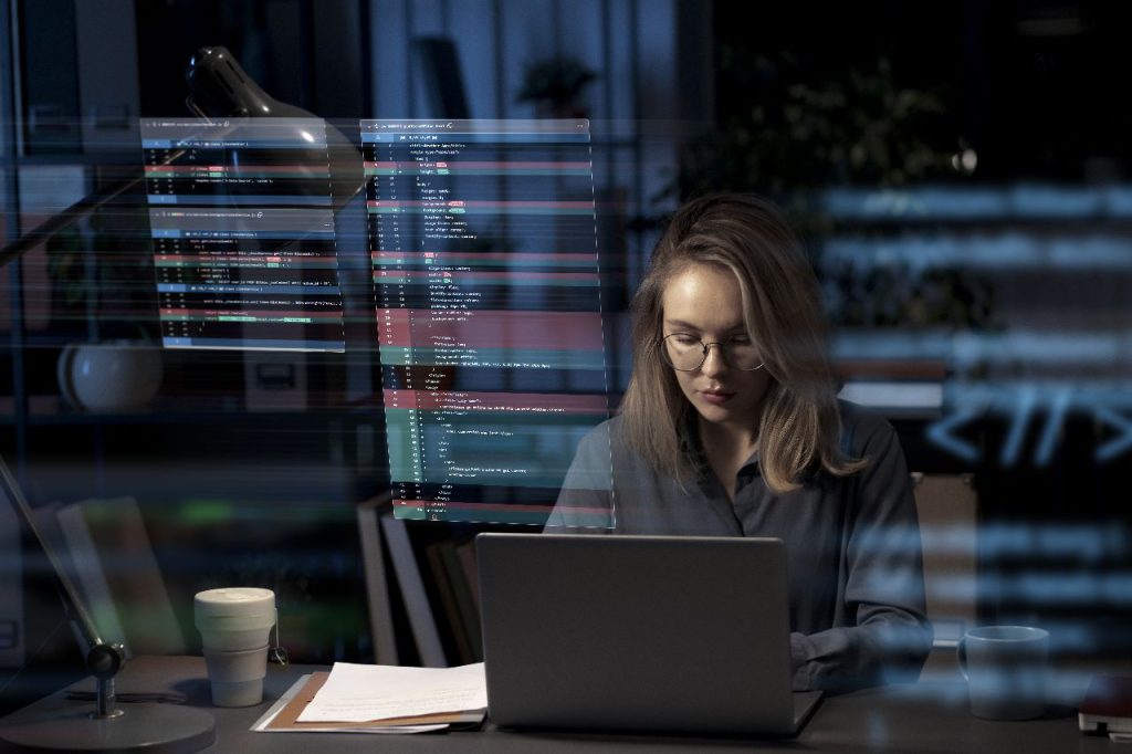 A imagem de uma pessoa imersa em códigos e dados em um laptop, destaca a complexidade e a estrutura subjacentes a sistemas digitais. Isso sugere que o conteúdo aborda como a 'copy' também requer uma estrutura lógica e um entendimento aprofundado para ser eficaz, tal como a construção de um código, para persuadir e gerar resultados.