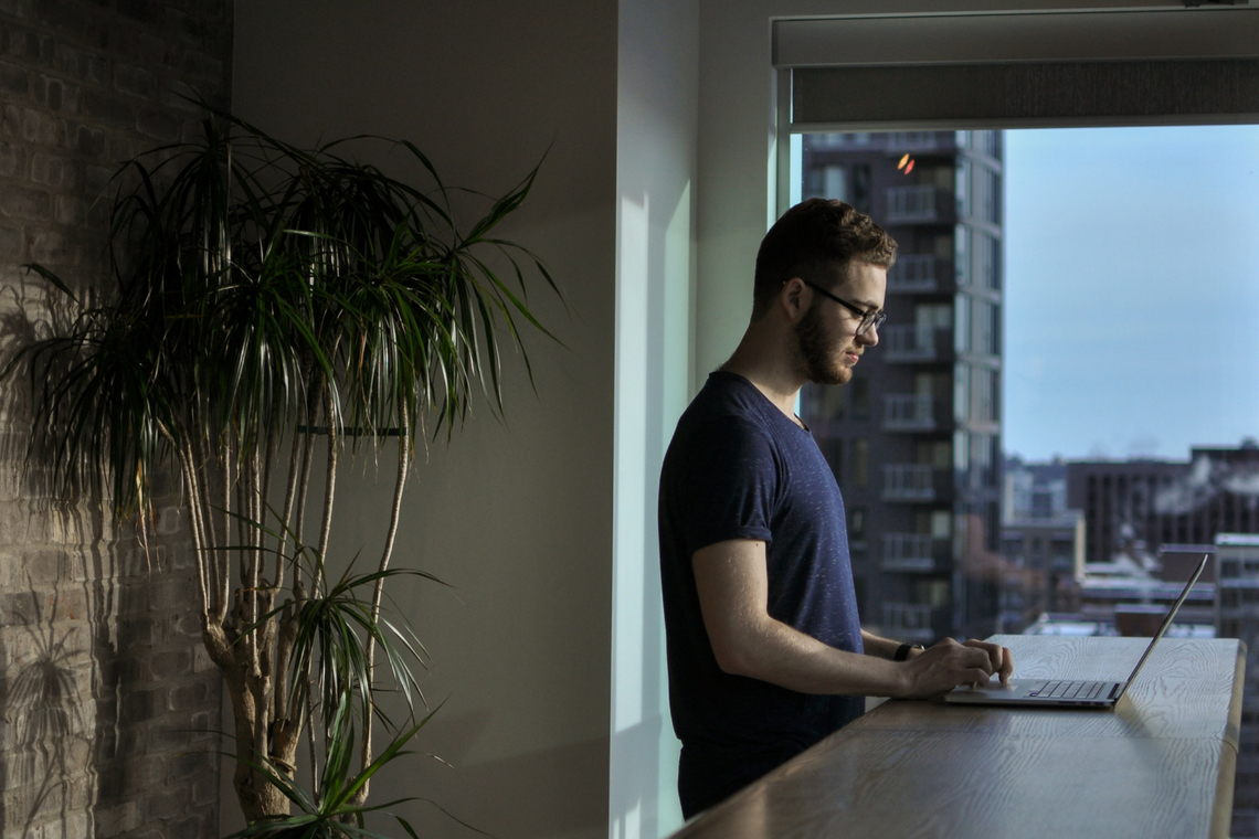 A imagem de um profissional trabalhando em seu laptop com uma vista inspiradora da cidade, destaca a produtividade em um ambiente autônomo. Isso sugere que o conteúdo aborda o estilo de vida de um 'freelancer' que valoriza a flexibilidade e a capacidade de moldar seu próprio espaço de trabalho e rotina.