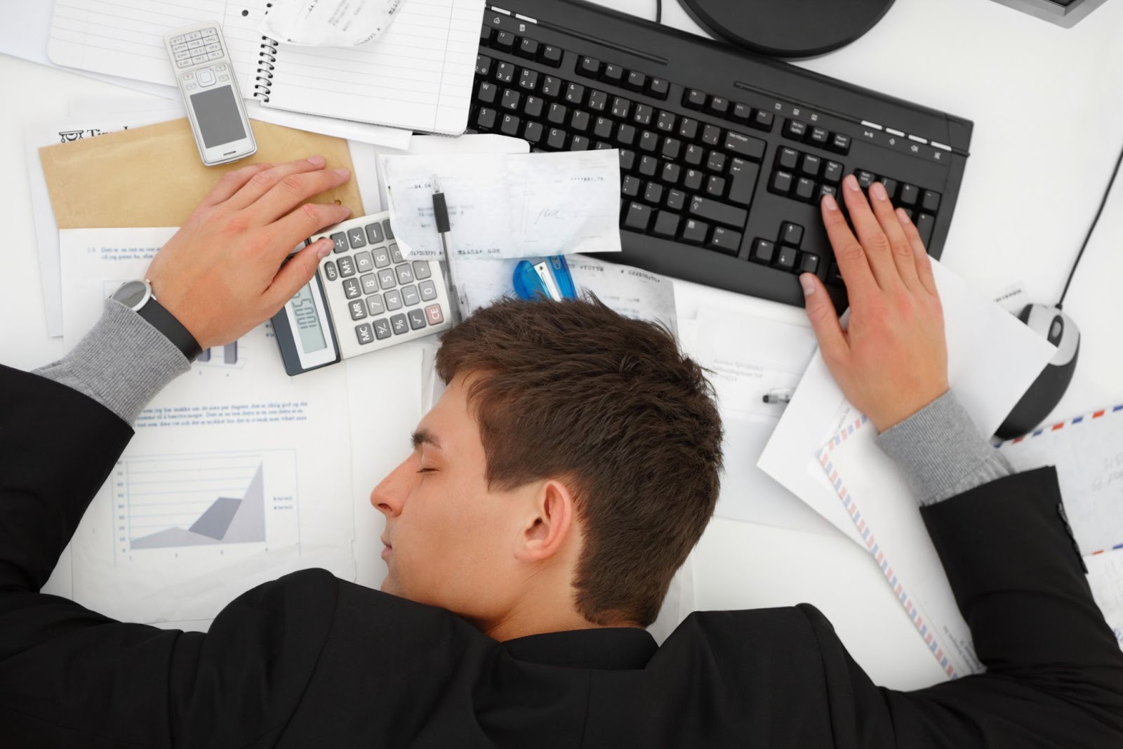 A imagem de um profissional exausto em meio a uma mesa de trabalho cheia, destaca a realidade da carga de trabalho em certas fases. Isso sugere que o conteúdo aborda os desafios de gerenciar projetos e tempo como 'freelancer', e a importância de encontrar estratégias para evitar o esgotamento.