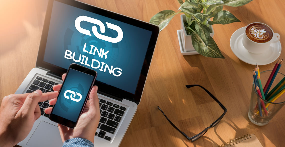 Dispositivos digitais (celular e laptop) exibindo o conceito de 'LINK BUILDING', com elementos de escritório. Isso simboliza a importância de construir conexões e o poder do 'Link building' para fortalecer a presença digital.