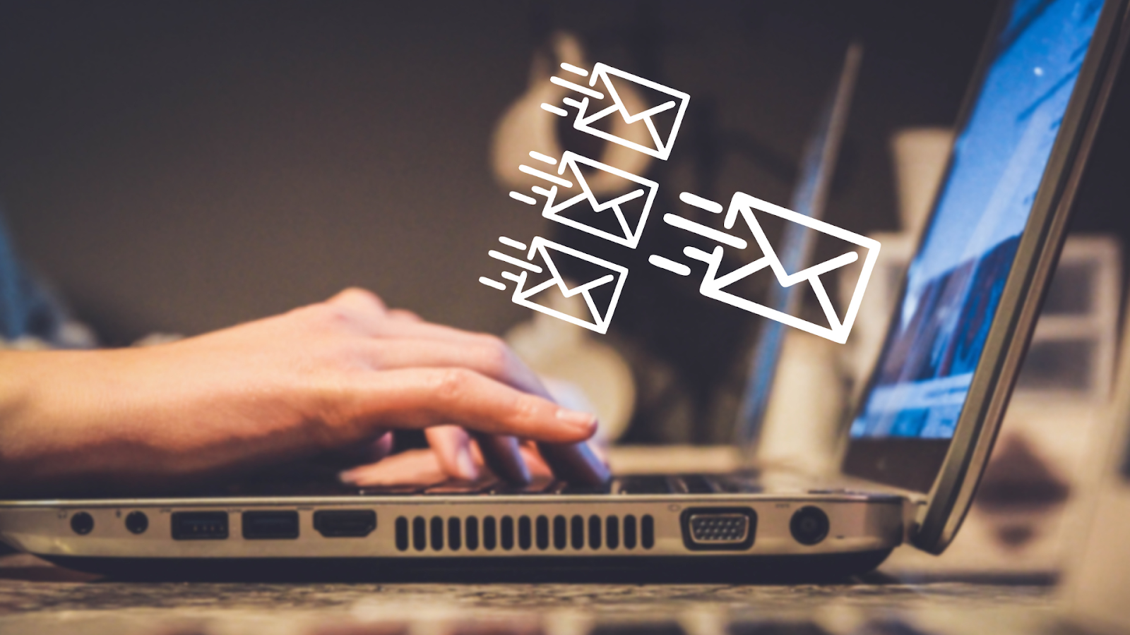 Mãos digitando em um laptop com ícones de envelopes (e-mails ou mensagens) flutuando para fora da tela. A imagem representa comunicação digital e envio de mensagens, podendo ser associada a estratégias de Vendas no Telegram.