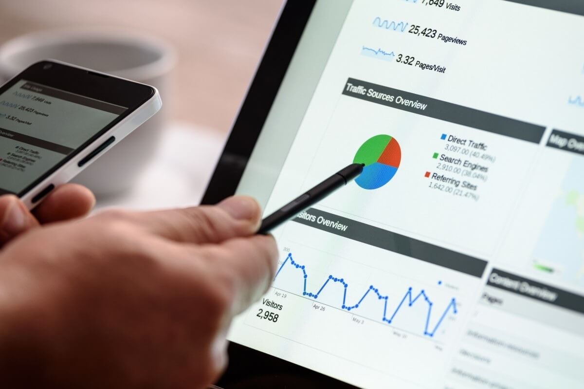 Tela de laptop exibindo gráficos de visão geral de tráfego e visitantes. Isso simboliza a análise de dados e a busca por insights para otimizar o 'tráfego' e o desempenho online.