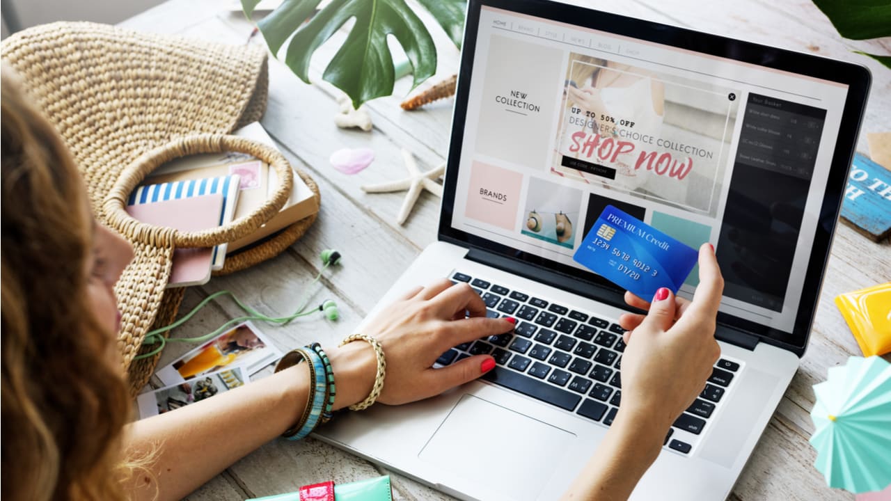 Mulher realizando uma compra online com cartão de crédito, ilustrando a conversão impulsionada por uma oferta Tripwire em uma loja virtual.